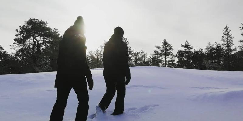 Bild på två personer som vandrar i snö.
